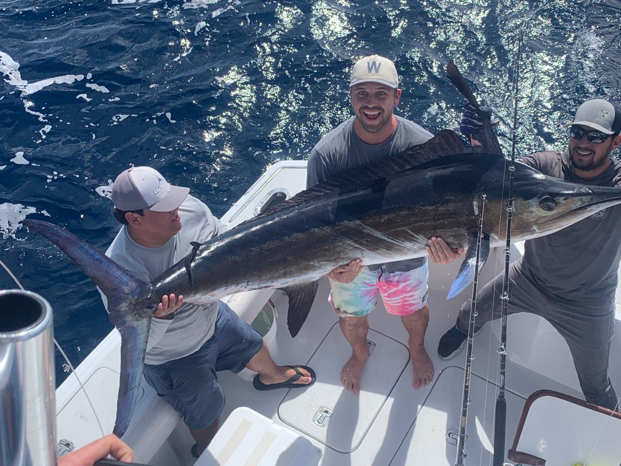 Crew and angler with a striped marlin boatside