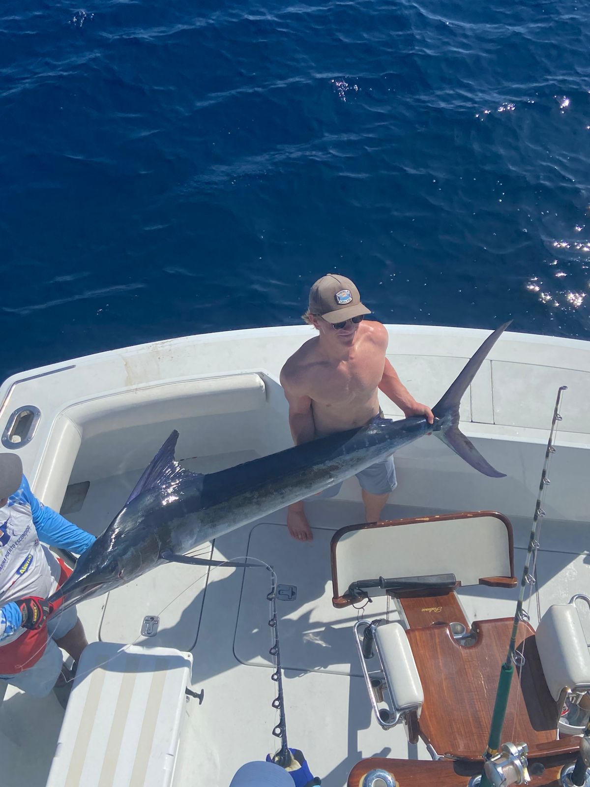 Angler tailing a striped marlin for release